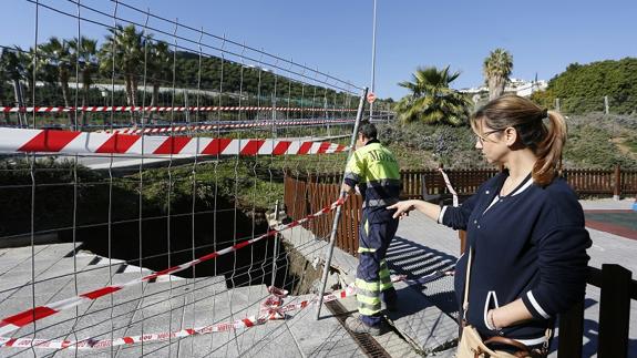 Mª José, hija del matrimonio que se hundió en el socavón observa cómo los trabajadores municipales precintan el agujero. 