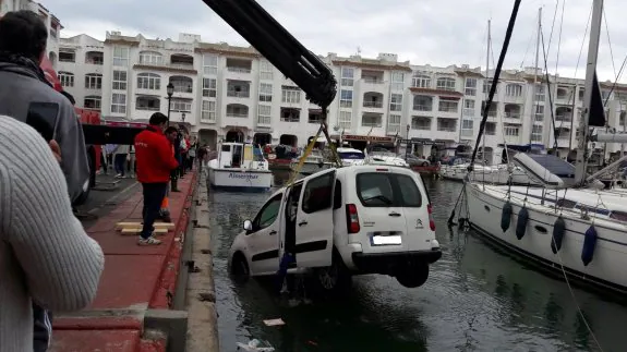 Una grúa extrae el vehículo sumergido en el puerto ejidense.