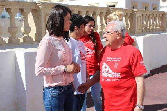 Ángeles Martínez charla con un voluntario de la Cruz Roja. 