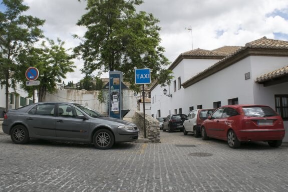 Coche estacionado en una parada de taxi e hilera de vehículos en la placeta de los Ortegas.