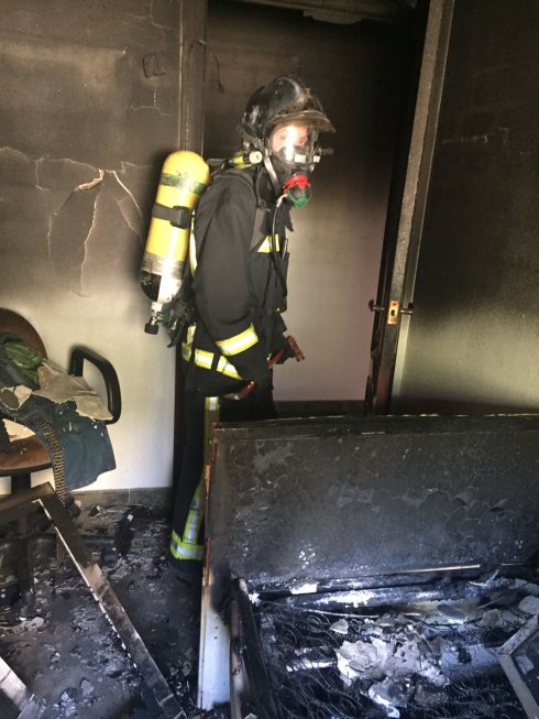 Un bombero en labores de extinción en el chalé.