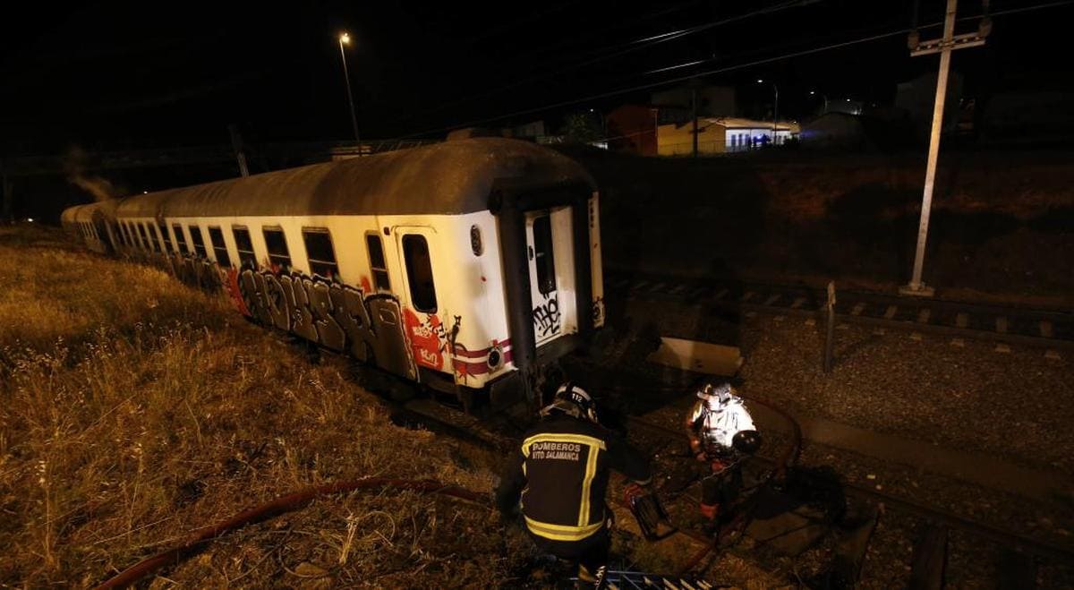 Arden dos vagones abandonados en una vía secundaria de la estación de tren