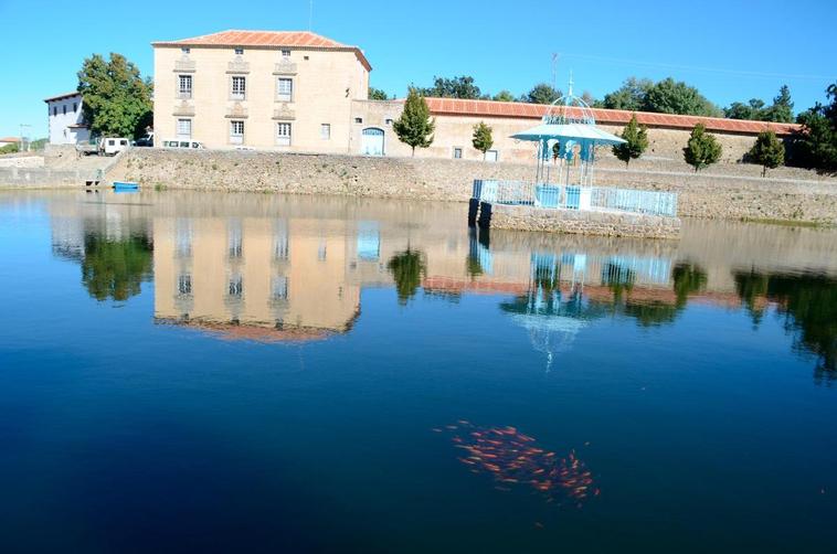 El palacete y las caballerizas de El Bosque, ya rehabilitadas, se reflejan sobre el agua del estanque, que también fue objeto de mejoras.