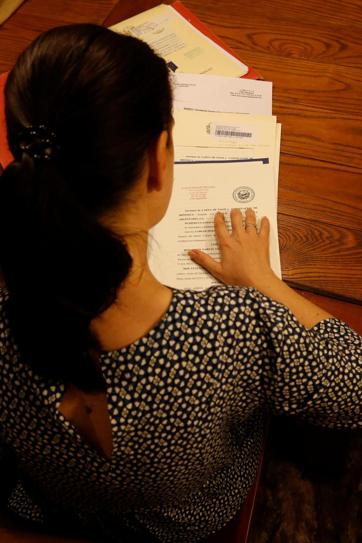Una mujer revisando el contrato de la hipoteca de la casa.