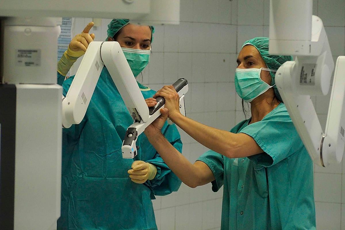 Personal de Enfermería prepara los ‘brazos’ del Da Vinci durante una operación de Ginecología.