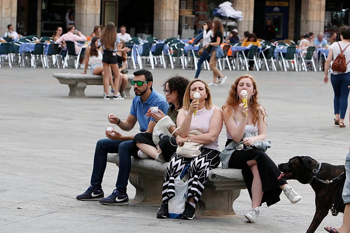 Varias personas comiendo un helado en la Plaza Mayor.
