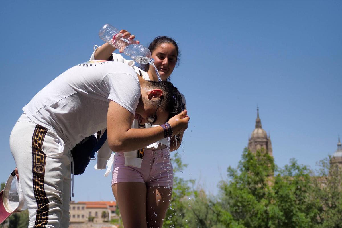 Dos jóvenes se refrescan en Salamanca.