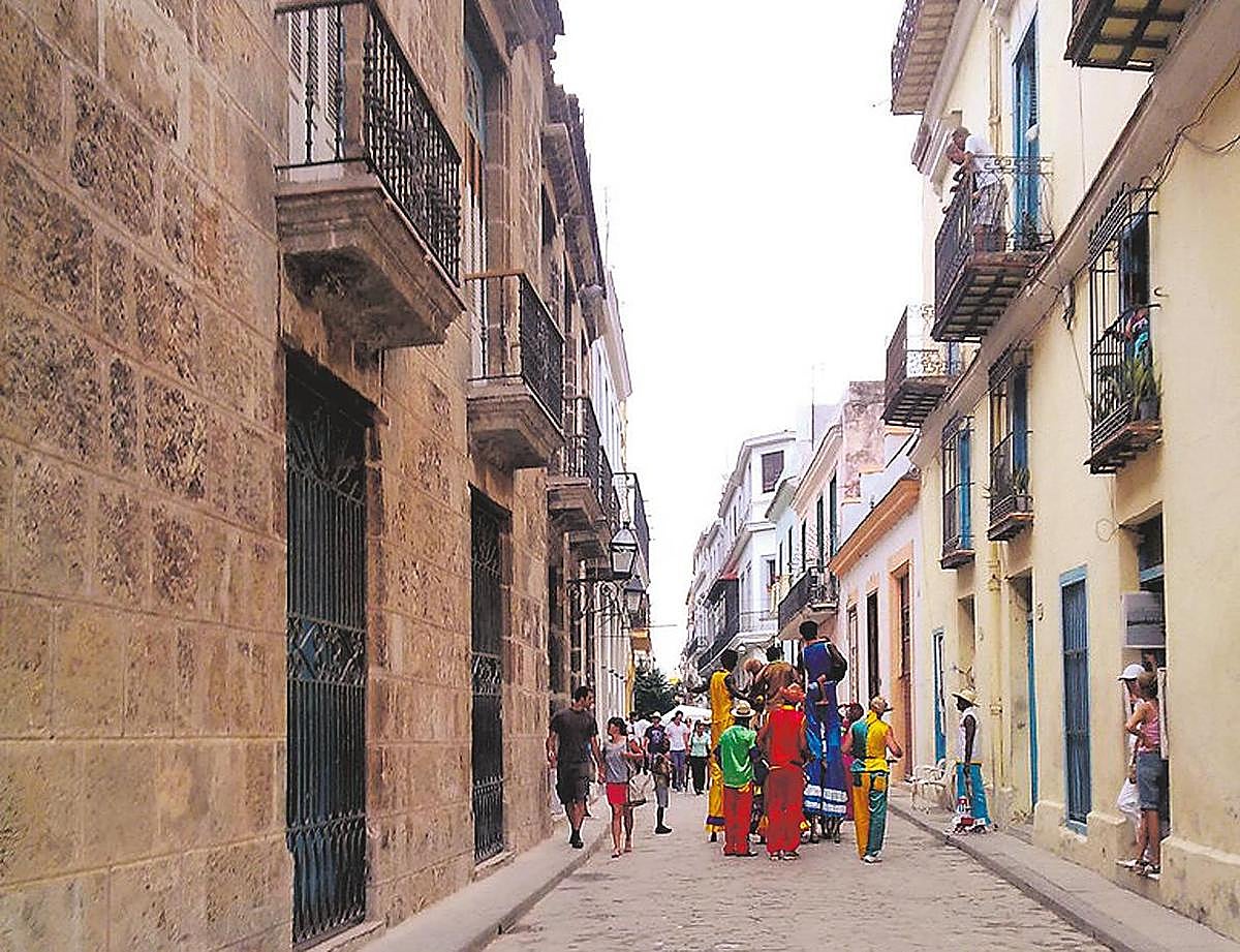 Un grupo de artistas ajeno a la noticia recorre las calles en unas fiestas populares.
