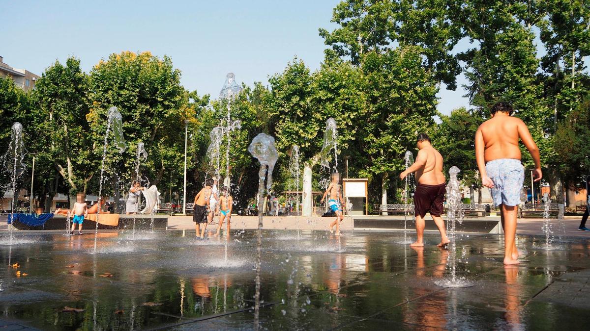 Personas bañándose en una fuente de Salamanca.