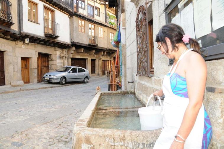 Una vecina de La Alberca cogiendo agua en una de las fuentes de la localidad serrana.