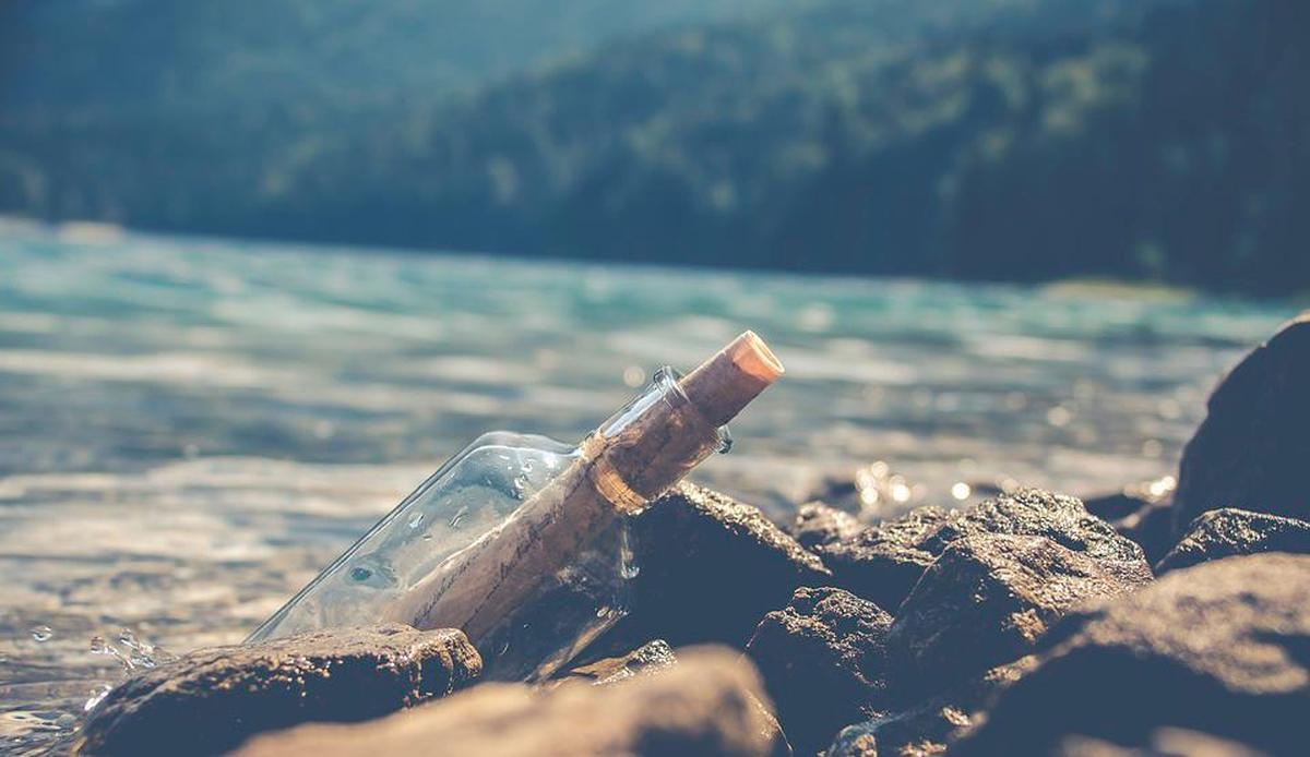 Botella con un mensaje en el mar.