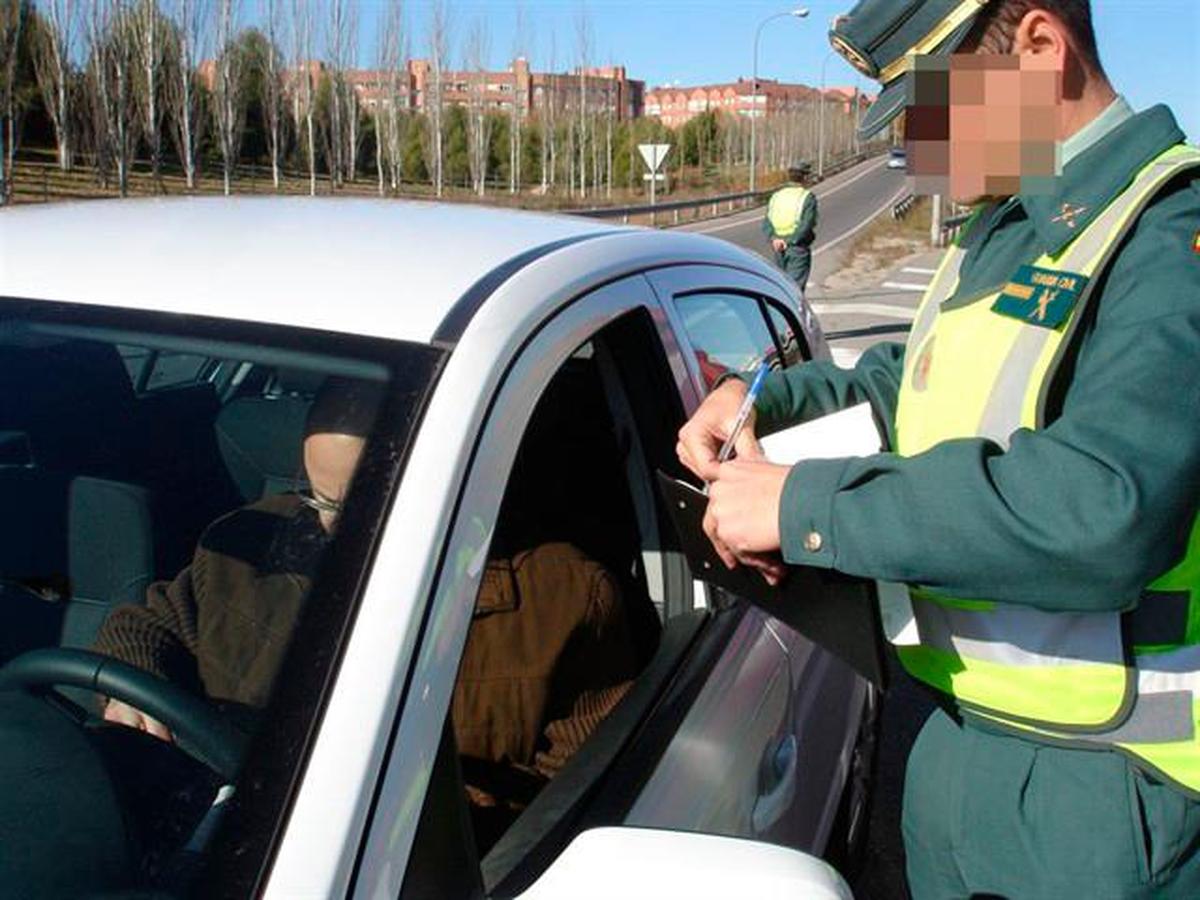 Un Guardia Civil poniendo una multa a un vehículo.