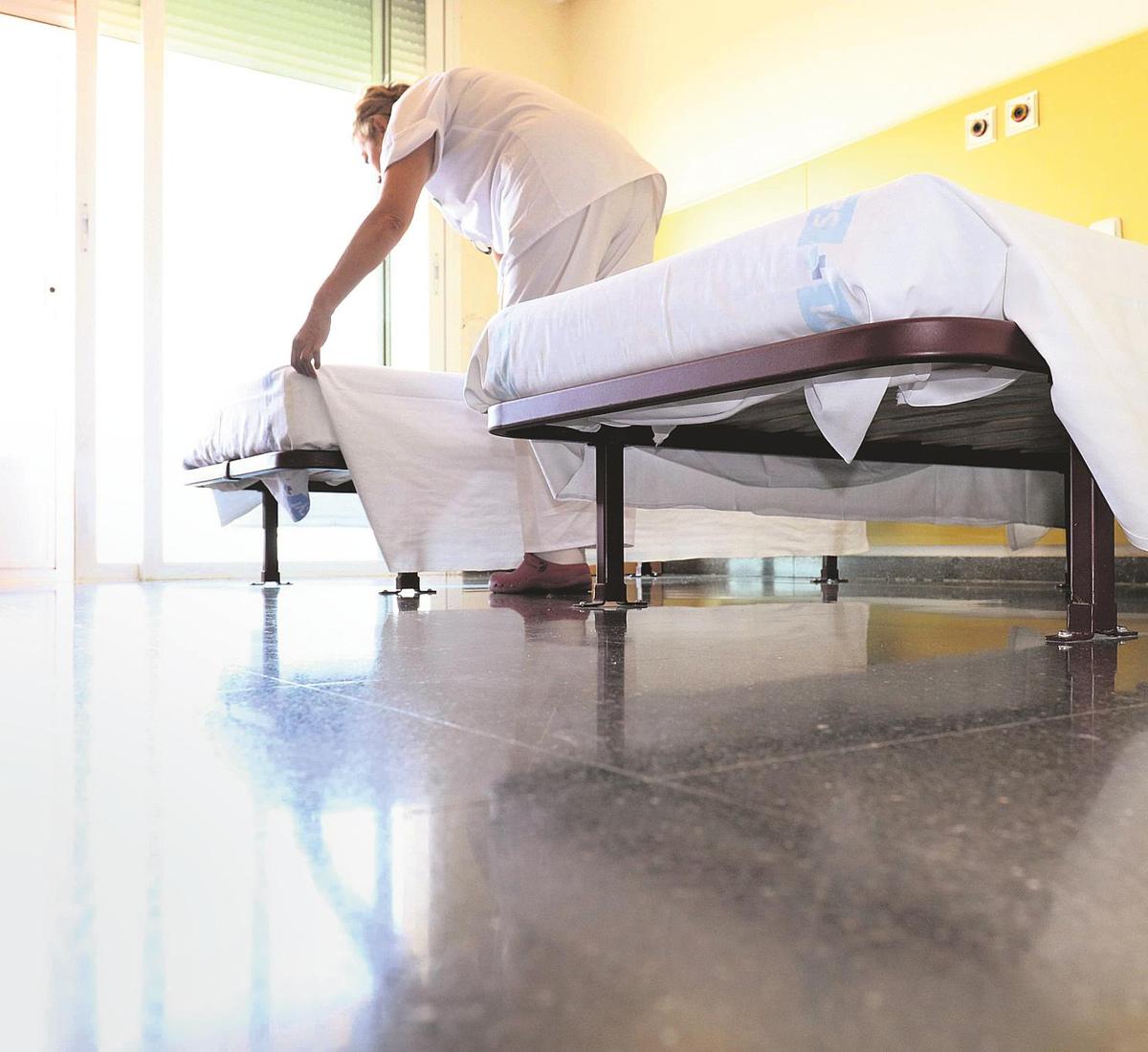 Una empleada del Complejo Hospitalario prepara la cama de una de las plantas de ingreso.