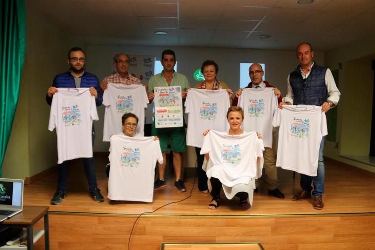 Varios organizadores muestran la camiseta solidaria.