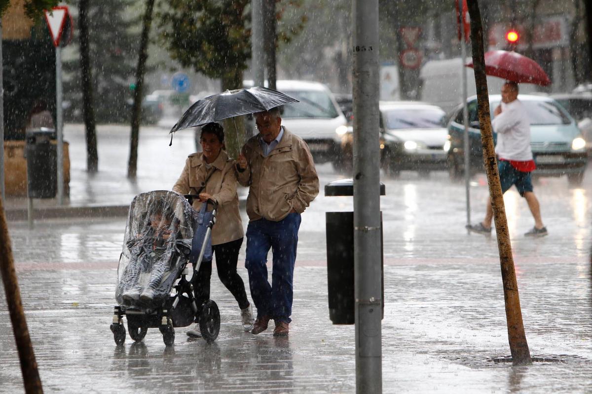 Dos personas pasean con un paraguas por Salamanca.