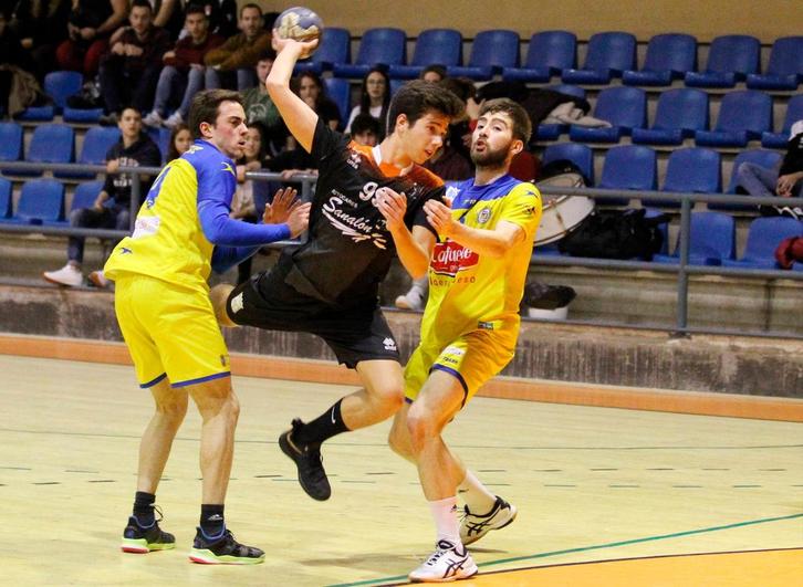 Álvaro Carretero intenta lanzar a portería ante dos rivales.