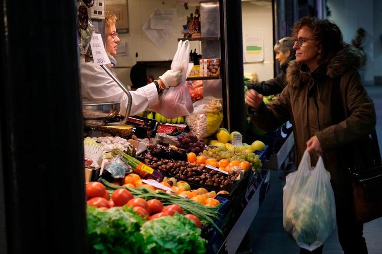 Varias clientas comprando en una frutería.