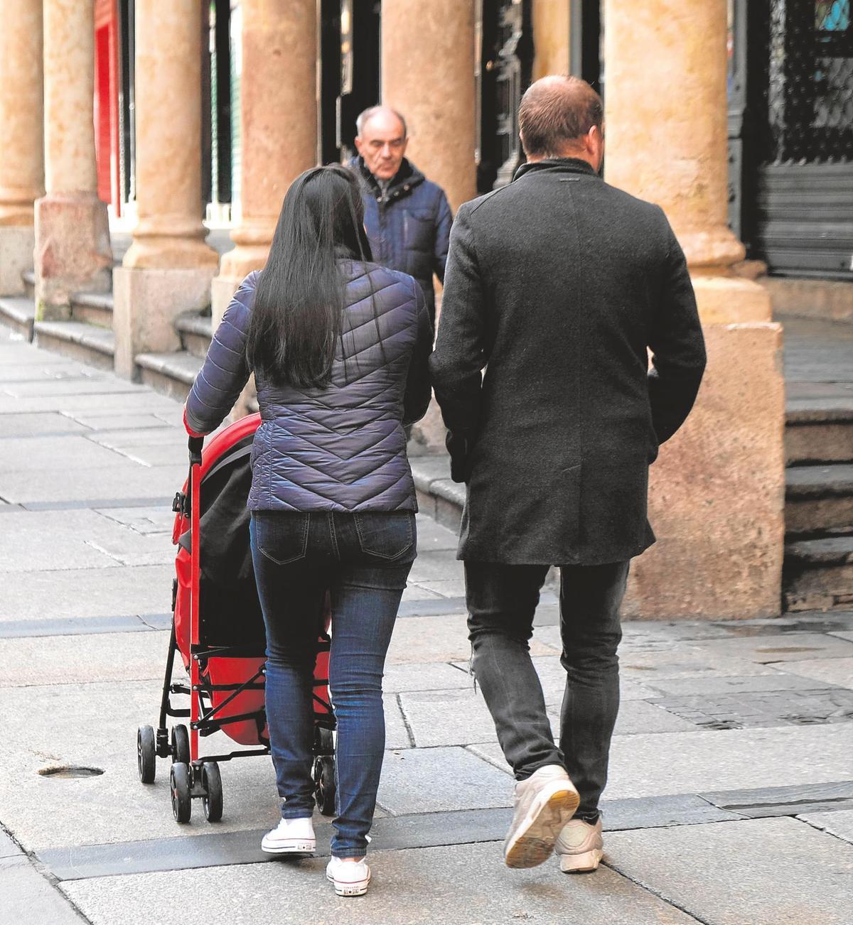 Una pareja pasea con su hijo por el centro de Salamanca.