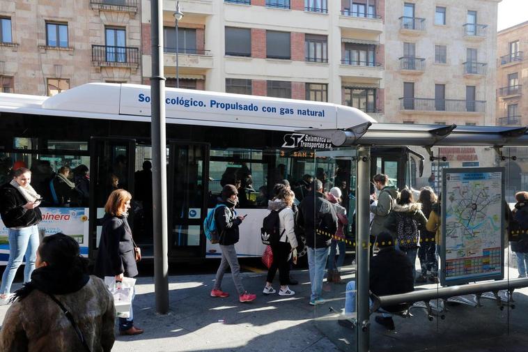 Jóvenes subiendo a un autobús urbano en una parada de la Gran Vía.