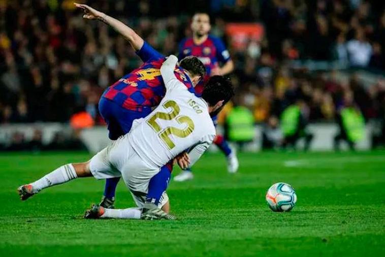 Rakitic e Isco disputan un balón durante un Clásico.