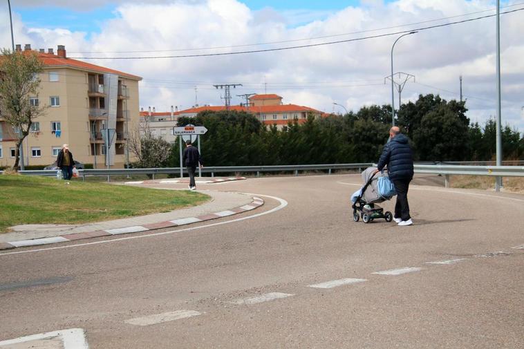 Los vecinos atraviesan la CL-510, entre las urbanizaciones de El Encinar y Los Cisnes, por la zona de la rotonda.