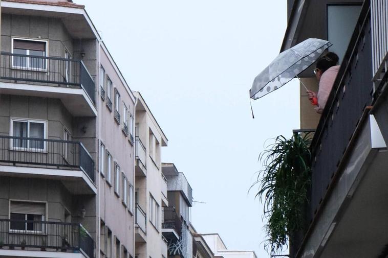 Una salmantina contempla desde su terraza el aguacero de este domingo en la capital.