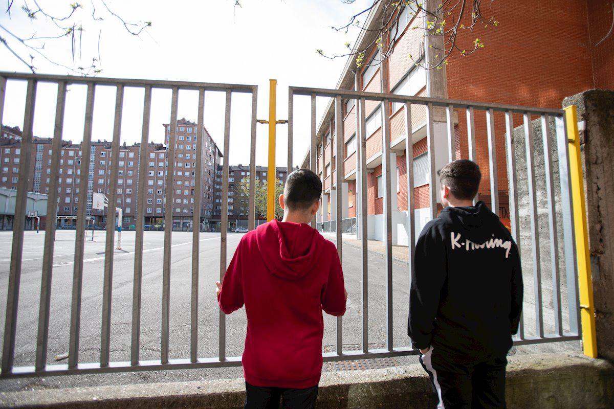 Dos adolescentes miran el interior de un instituto.