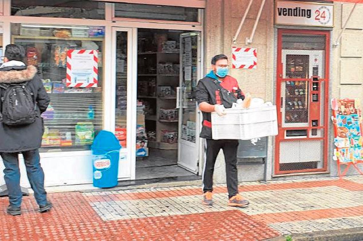 Imagen de Rubén Sánchez saliendo de su kiosco para repartir los pedidos a domicilio.