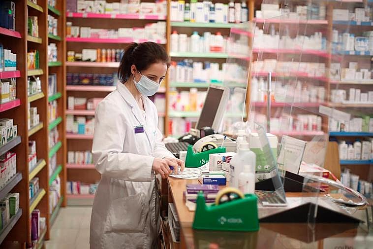 Una farmacéutica revisa medicinas en su establecimiento