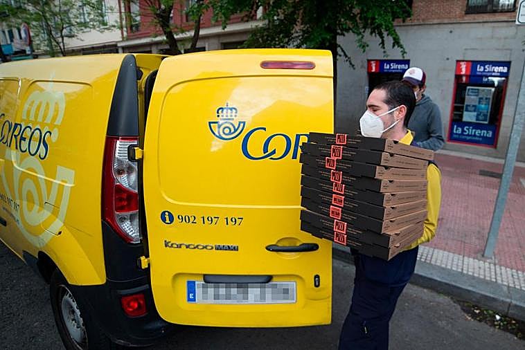 Un empleado de Correos transporta pizzas durante el confinamiento