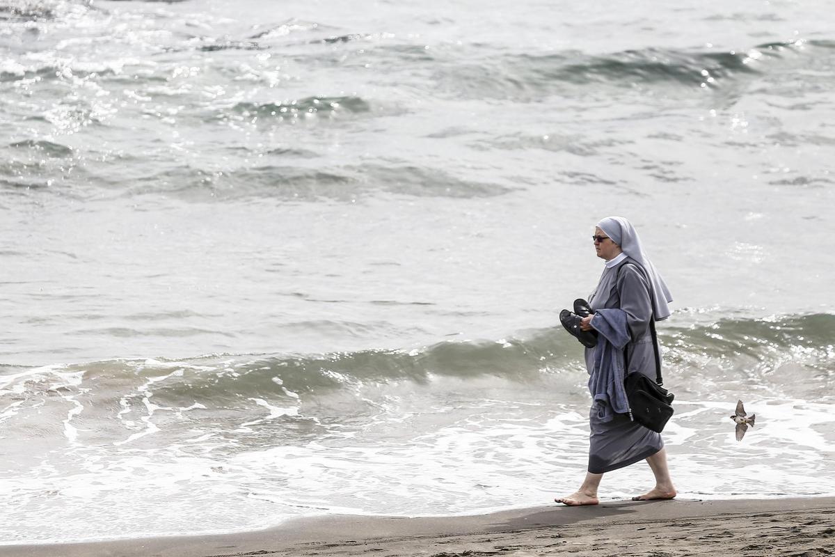 Una religiosa paseando este domingo por una playa de Ladispoli (Italia).