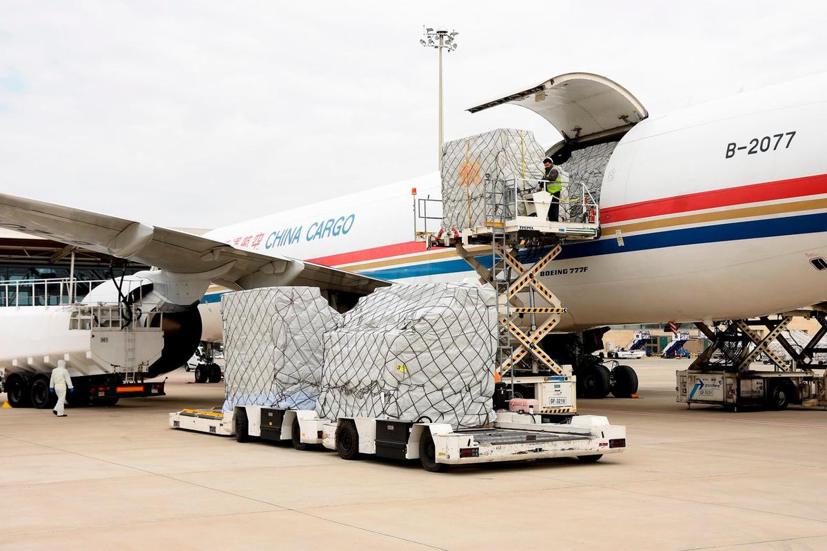 Descarga de un avión con mascarillas compradas por la Junta