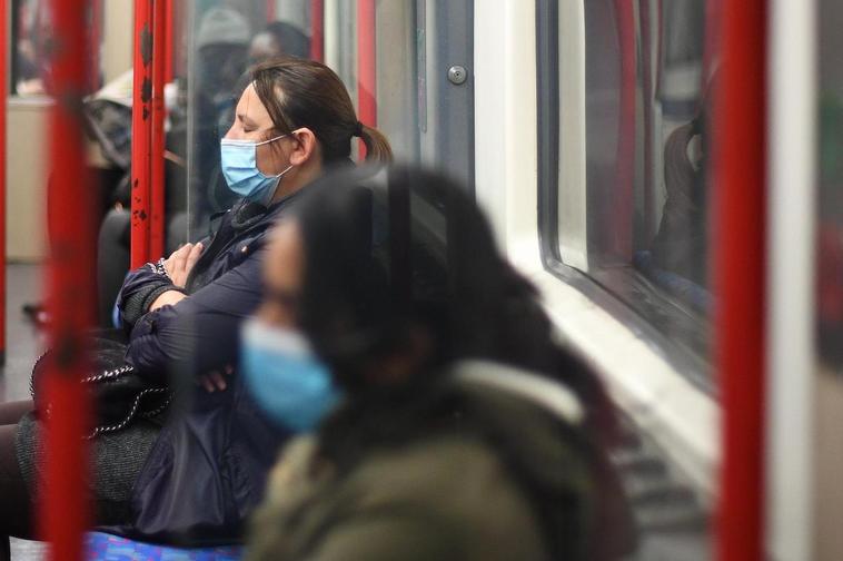 Pasajeros en el transporte público del país británico con mascarillas.