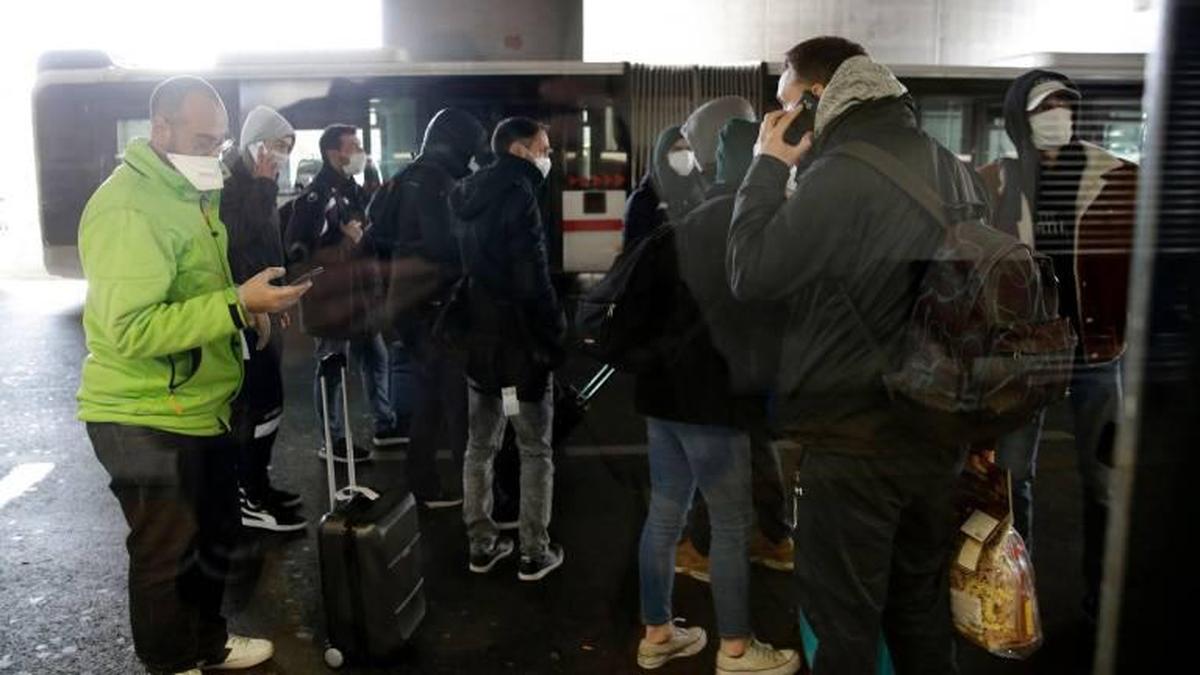 Erasmus salmantinos con máscaras junto a un autobús de la ciudad italiana de Milán.