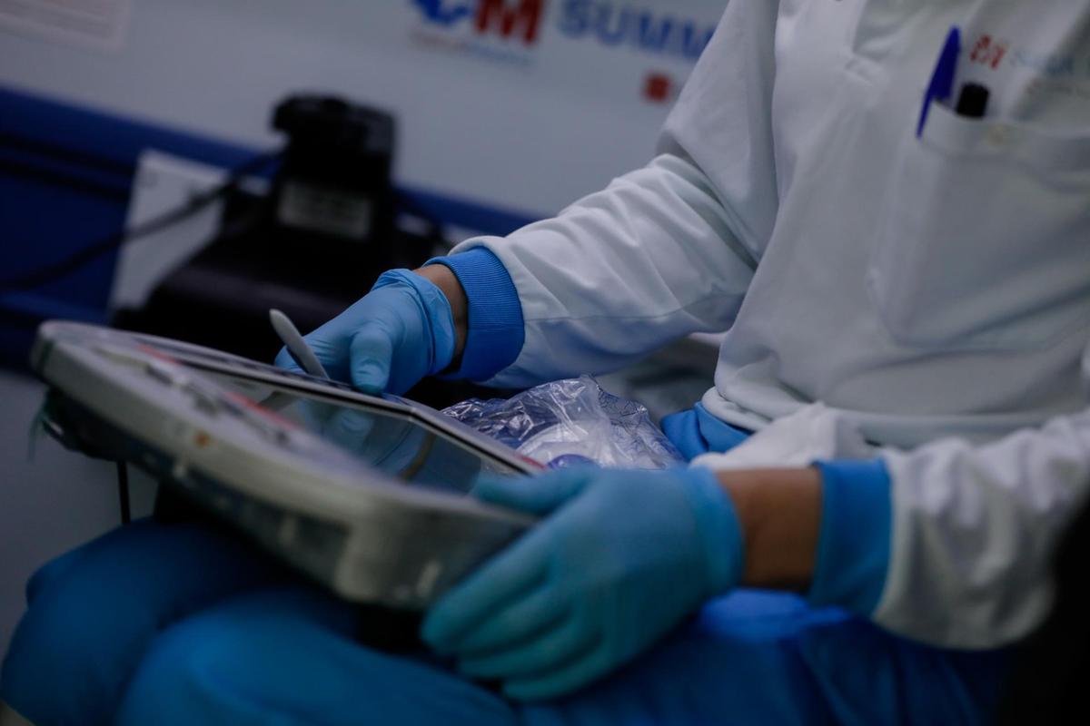 Una sanitaria consulta una tablet durante el cambio de guardia de la unidad móvil.