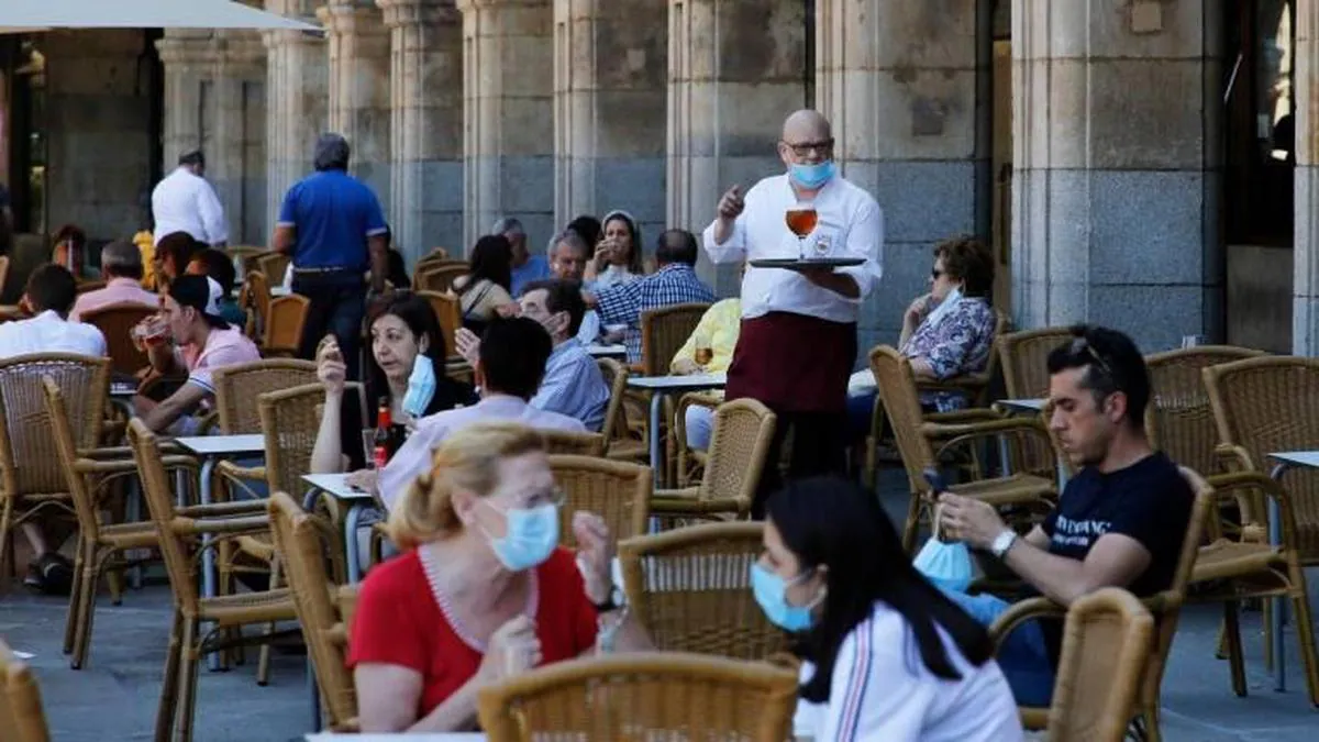 Un camarero sirviendo en una terraza de la Plaza.