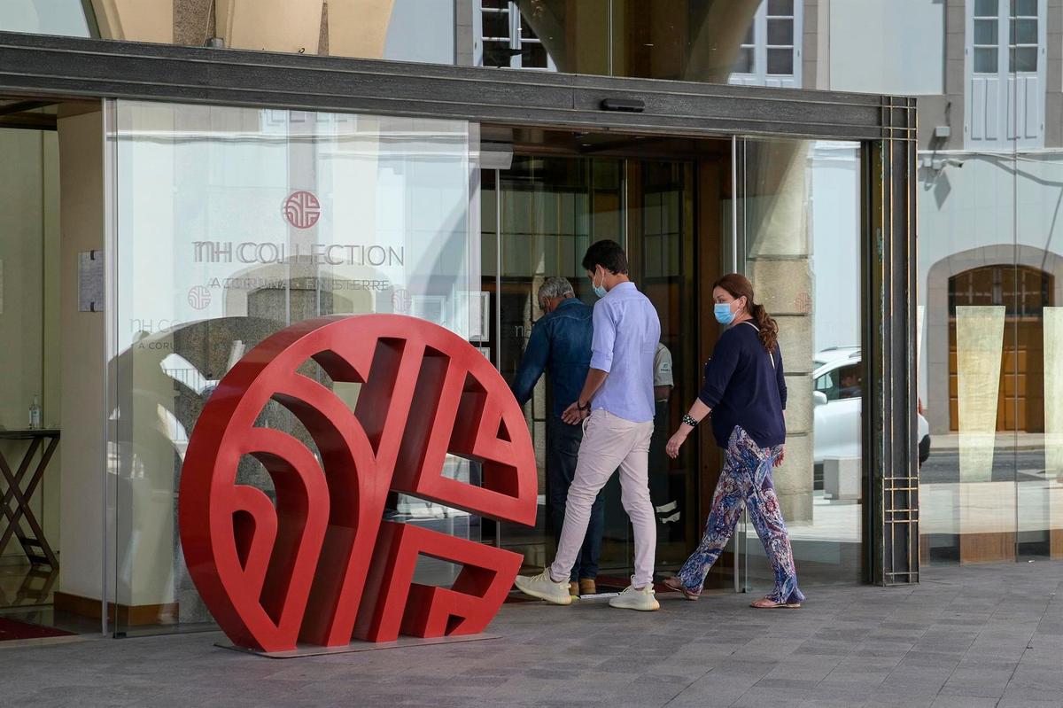 Dos personas entran por la puerta del hotel donde los jugadores del CF Fuenlabrada permanecen confinados.