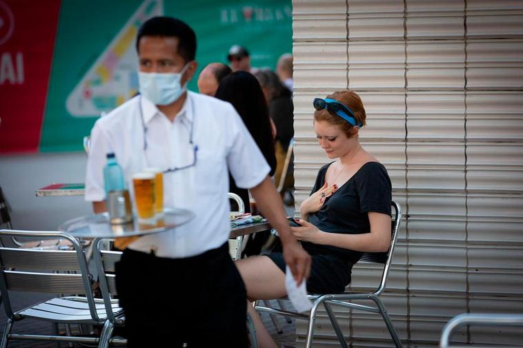 Un camarero sirve en la terraza de un bar.