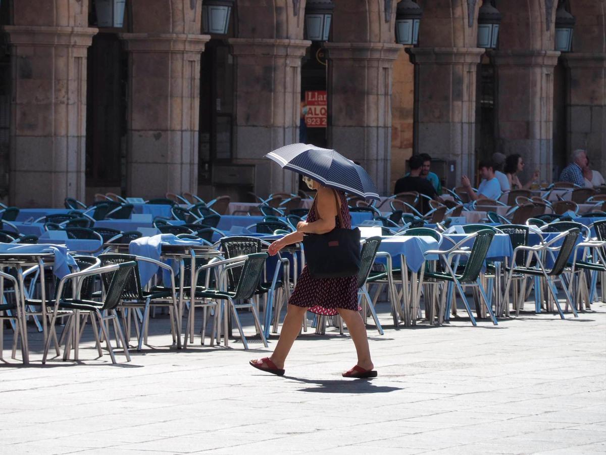 Una mujer se protege con un paraguas de las altas temperaturas.