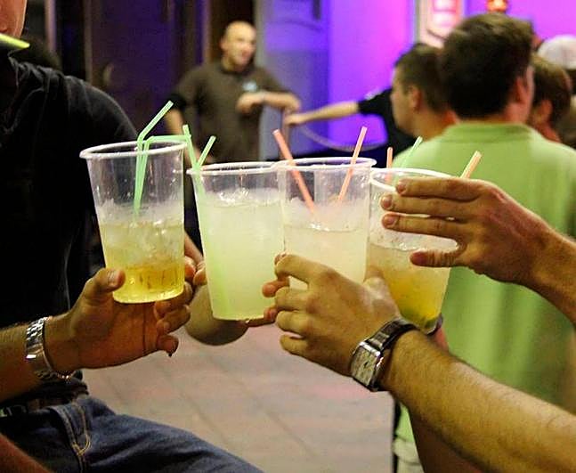 Varias personas sujetando bebidas.