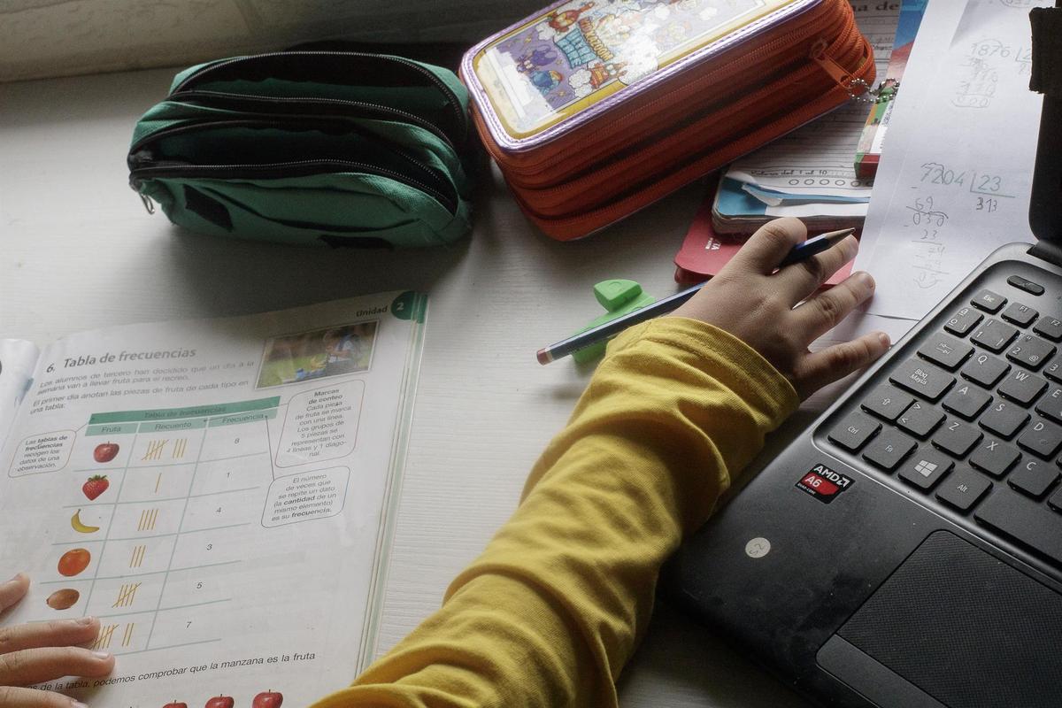 Un niño estudia y hace los deberes en casa.