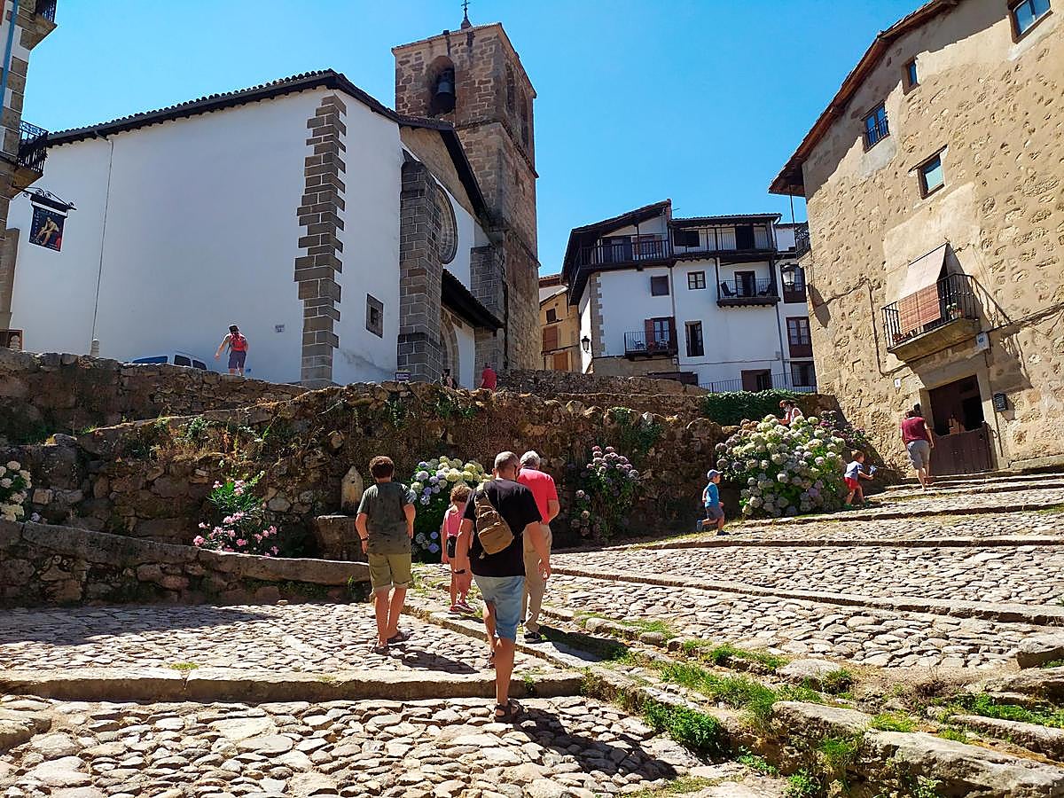 Imagen de la Cuesta de la Romana con vecinos y turistas disfrutando del verano en Candelario.