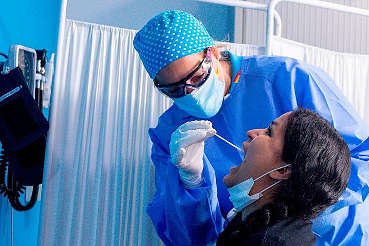 Un sanitario realiza a una mujer un test PCR.