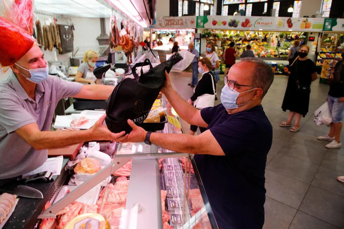 Entrega de un jamón en una carnicería del Mercado Central.