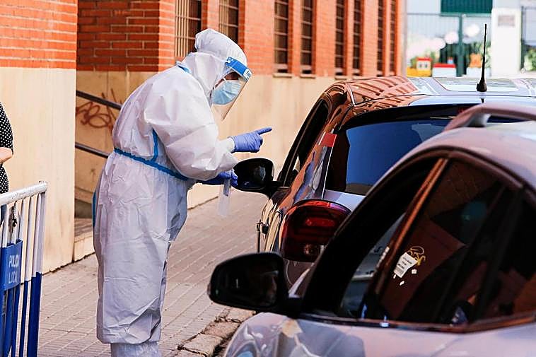 Un sanitario realiza una prueba PCR en el COVID Auto de La Alamedilla.