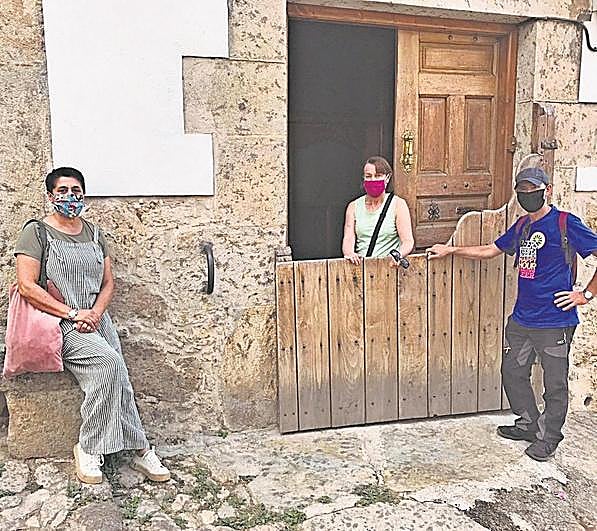 Marisa Macías, María José Martín y Antonio Hinojal, junto a una de las batipuertas existentes en Candelario.