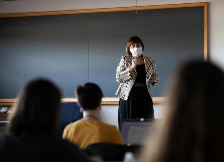 Una profesora imparte clase de manera presencial.