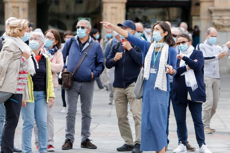 Una guía turística se dirige a varios visitantes en la Plaza Mayor de Salamanca.