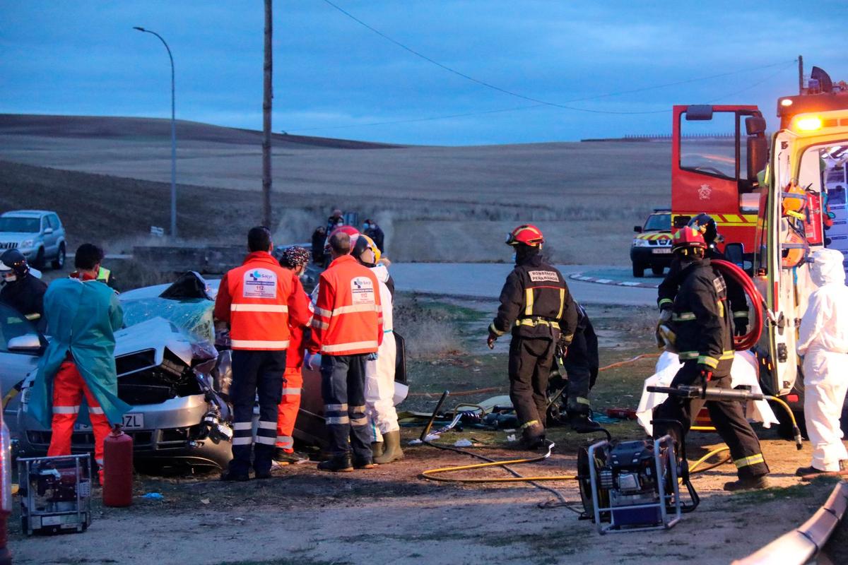 Sanitarios y bomberos atendiendo a la conductora herida en el accidente.