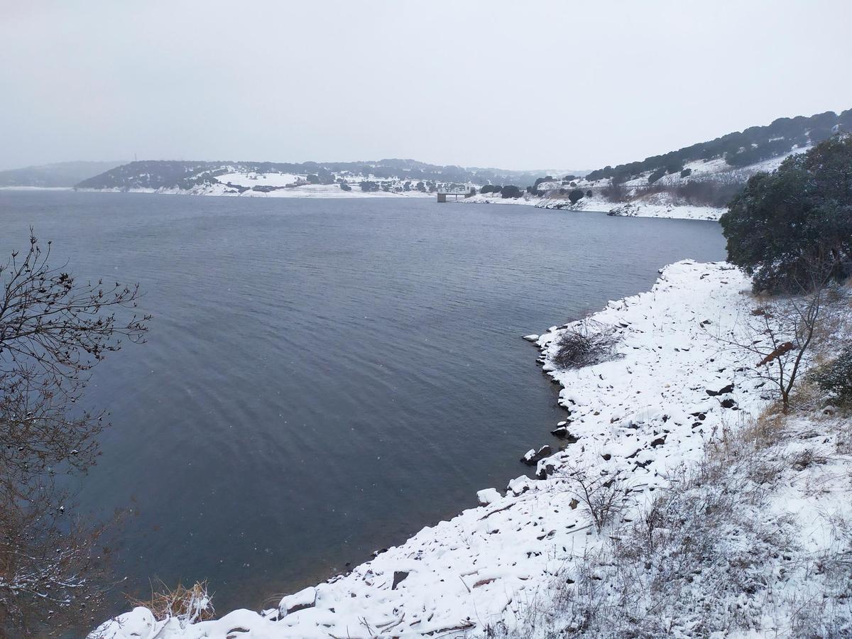 Imagen del pantano de Santa Teresa rodeado de nieve tras las precipitaciones del pasado viernes.